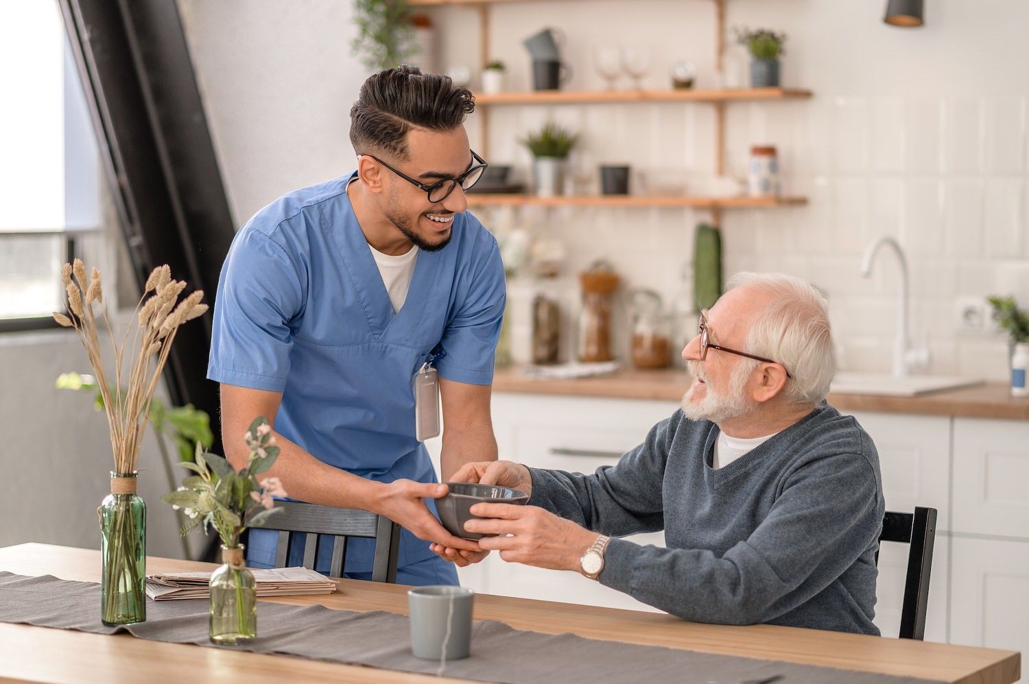 Caregiver serving senior man breakfast